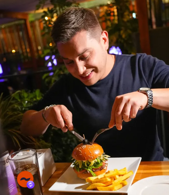 Cliente disfrutando una hamburguesa de la casa en Antonia Lounge